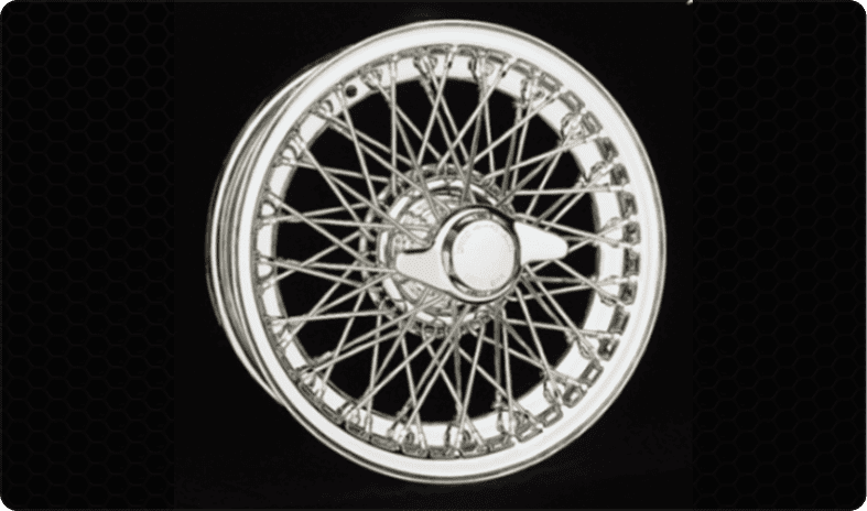 Chrome wire-spoke car wheel on black background.