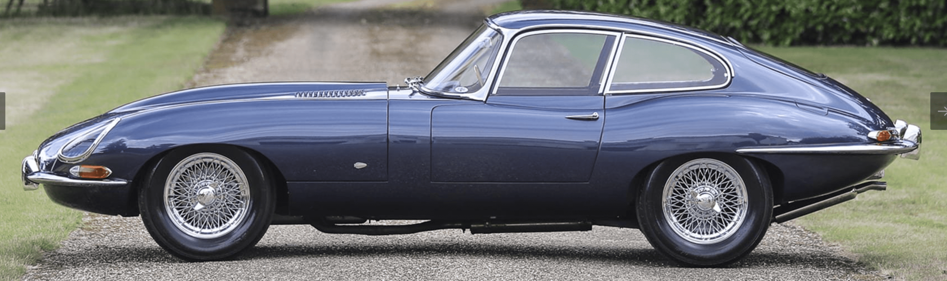 Classic blue sports car on a road.