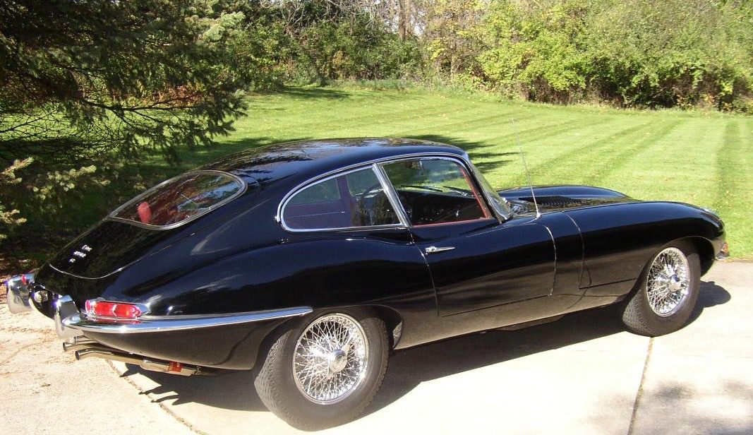 Black classic car parked on driveway.