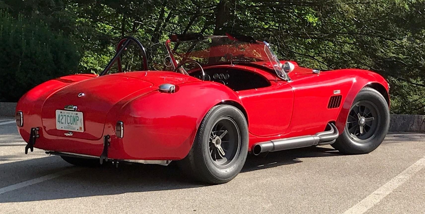 Red vintage convertible car on the road.