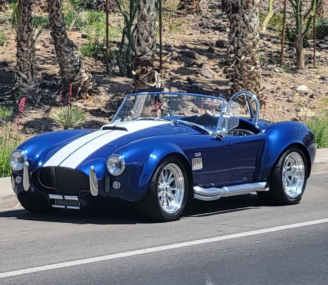 Blue classic car with white racing stripes.
