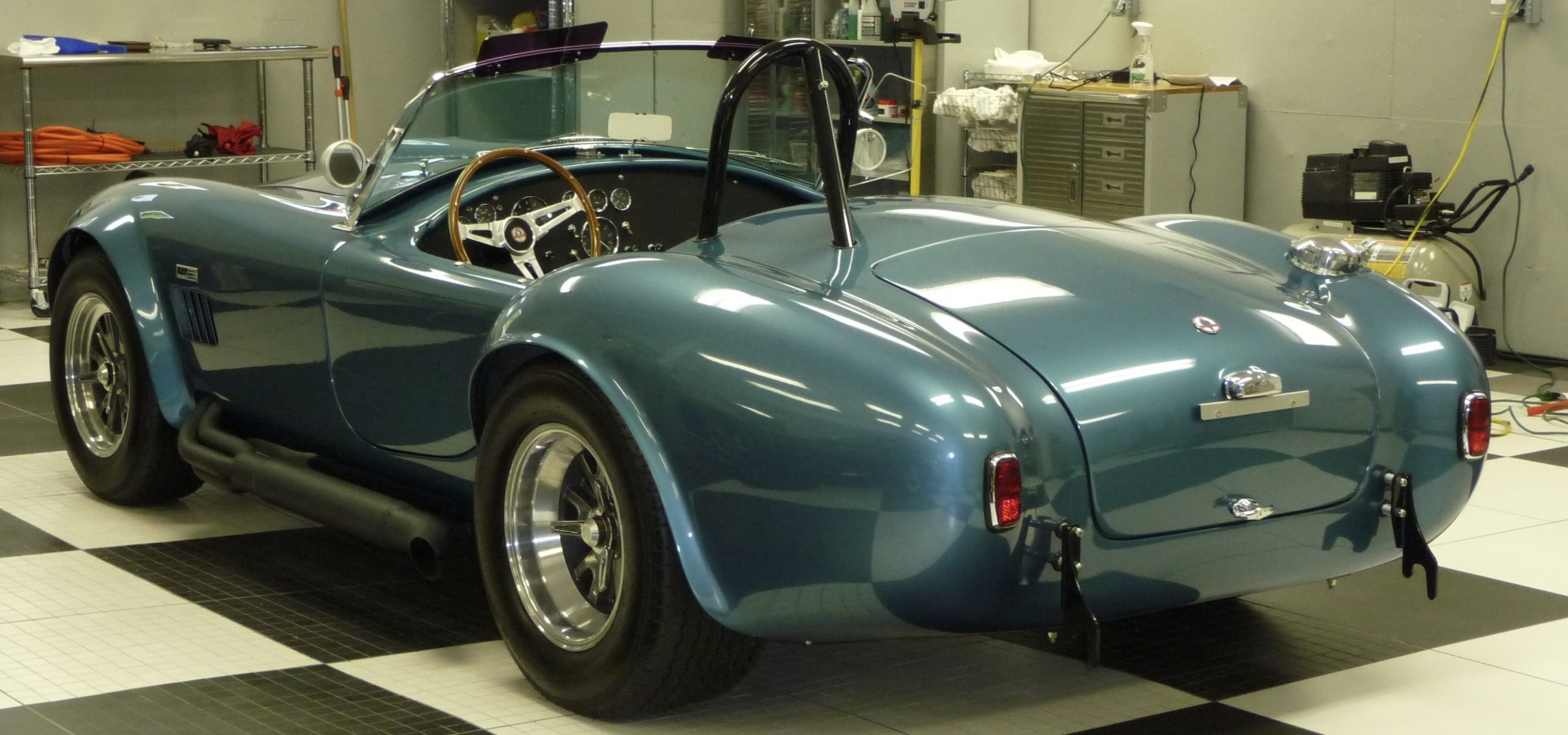 Blue vintage sports car in a garage.