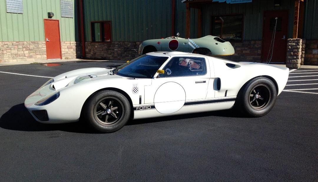 Vintage white sports car parked outside building.
