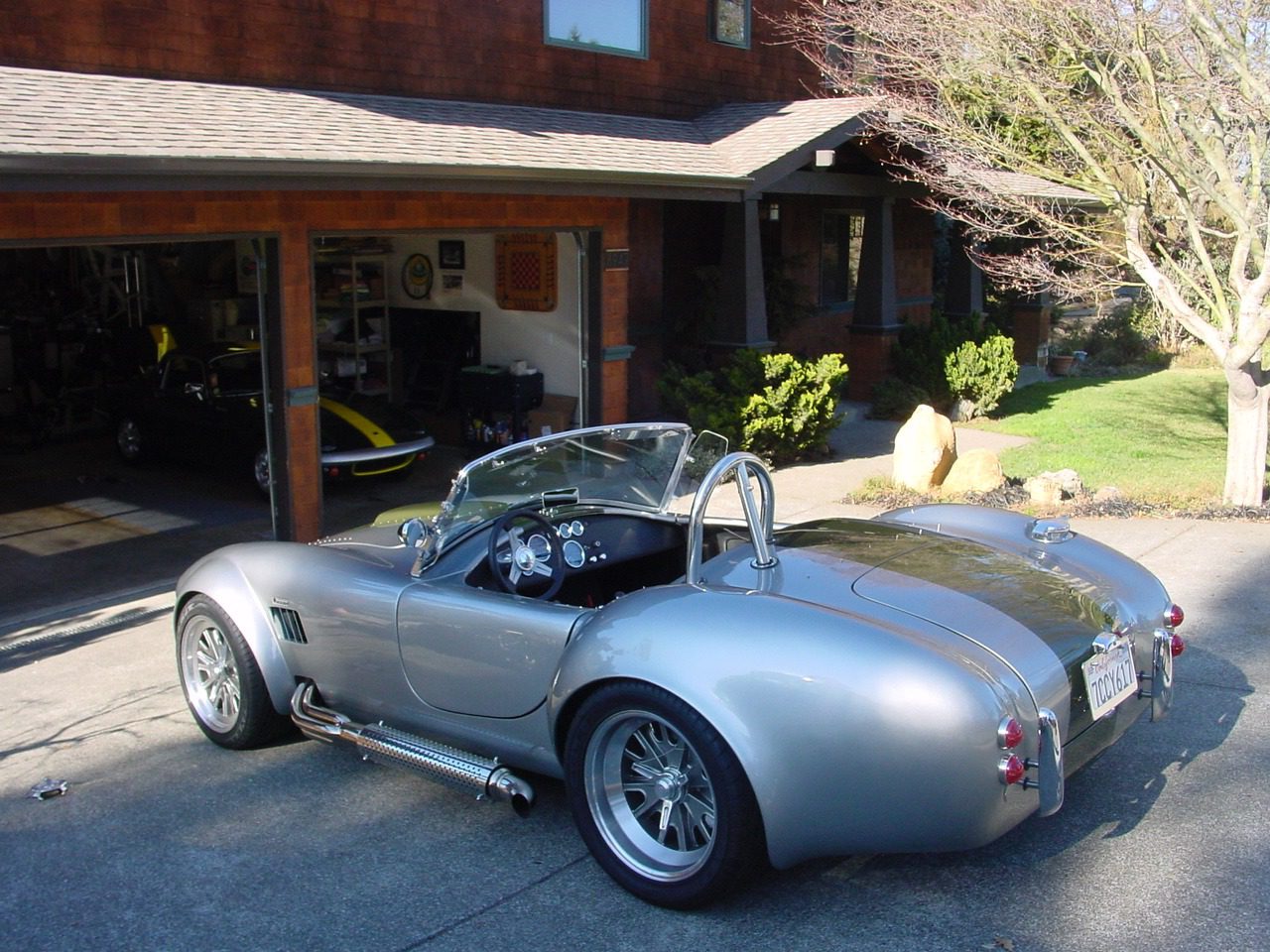 Silver vintage car parked near garage.