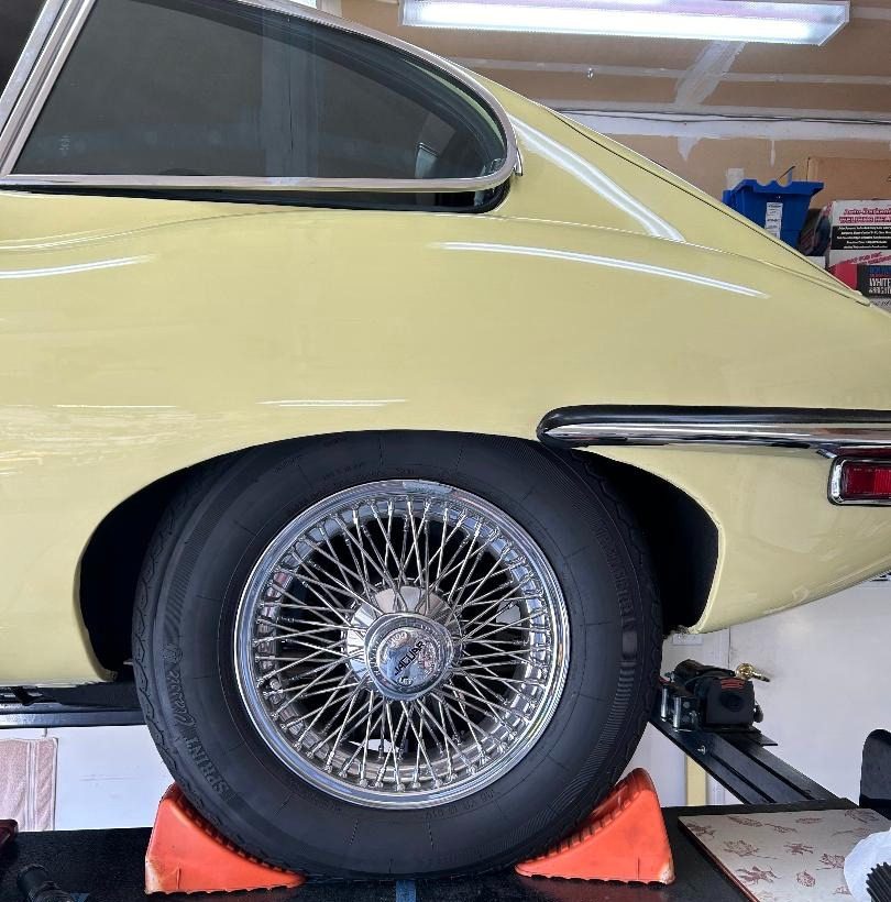 Vintage car wheel on display stand.