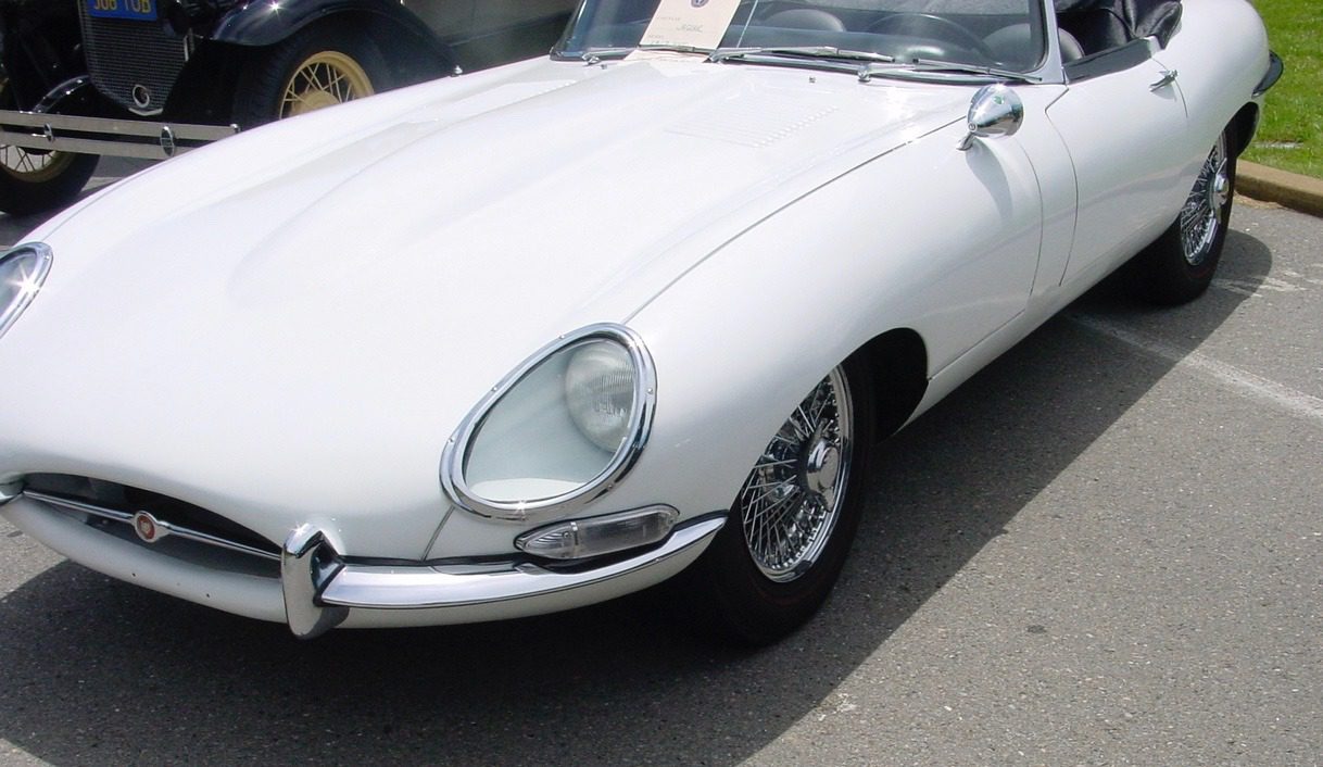 White vintage sports car on display outside.