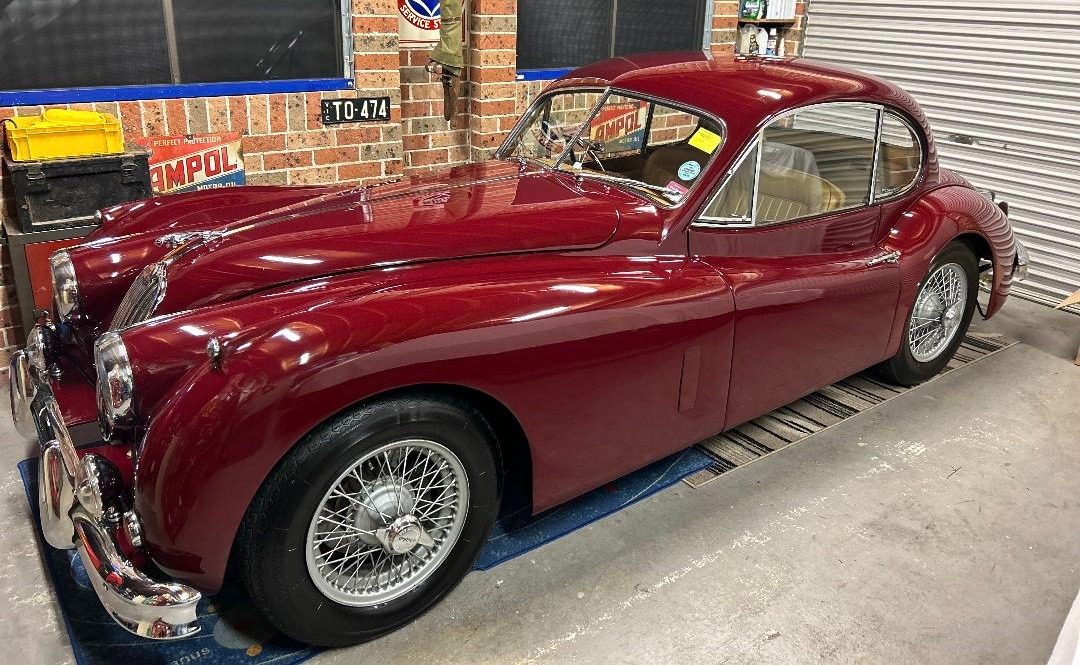 Red vintage car parked in a garage.
