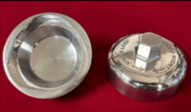 Two metal objects on red background.