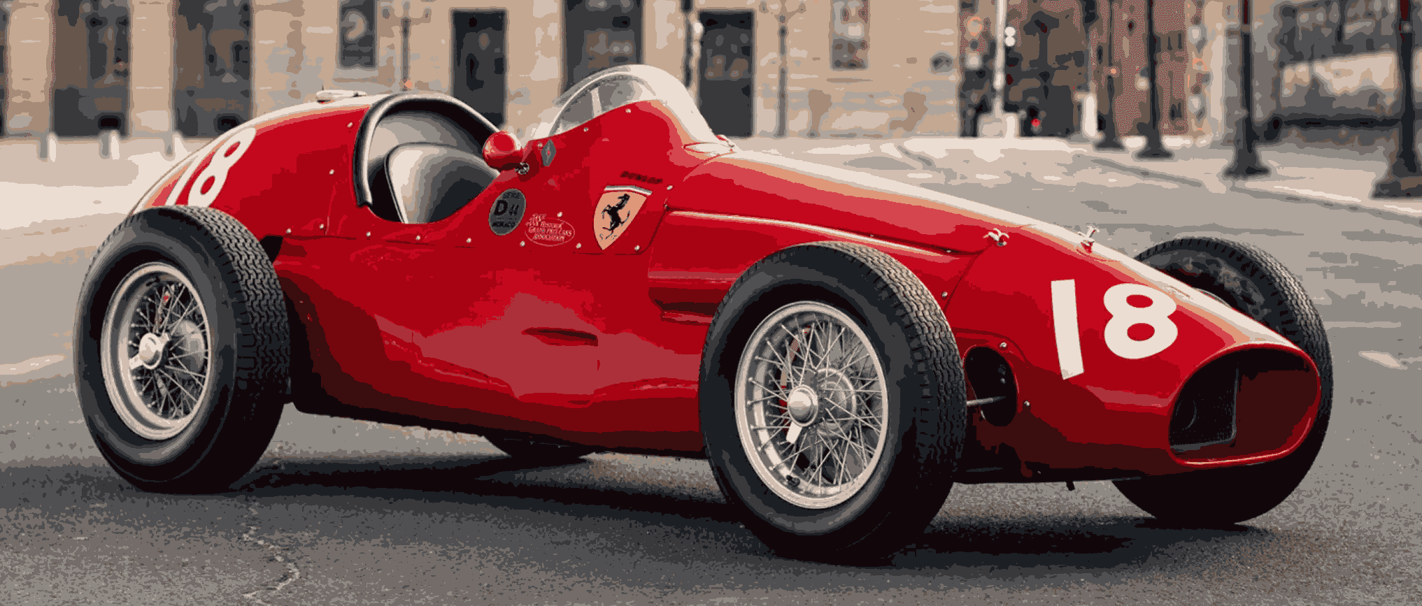 Red vintage race car on city street.