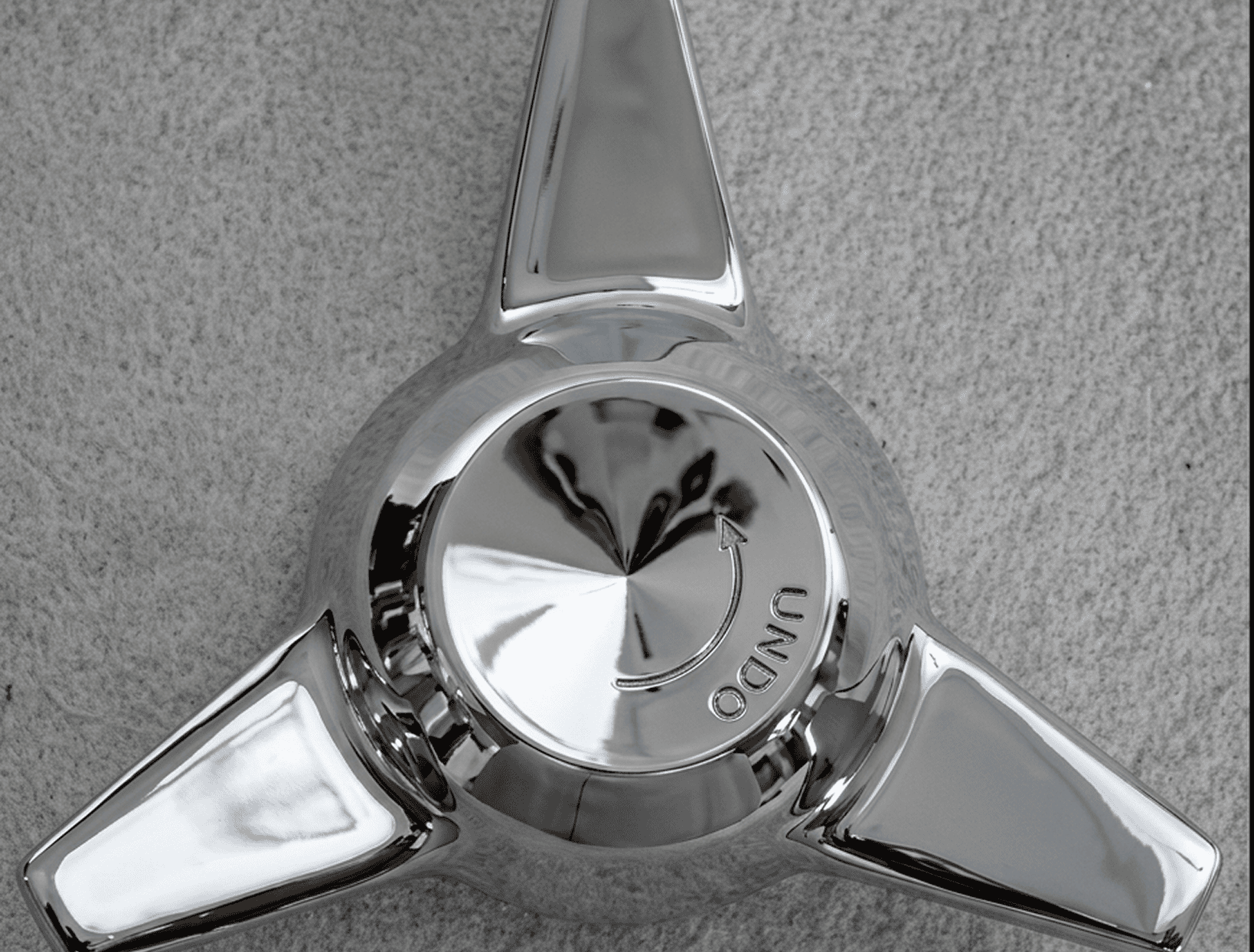 Chrome three-prong wheel spinner with "UNDO